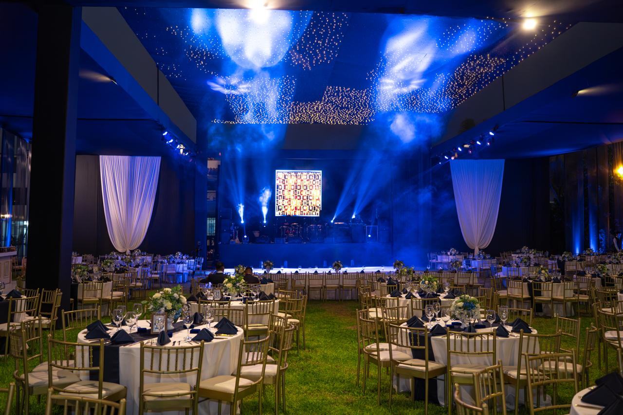 Salón de gala con mesas redondas y luces azules